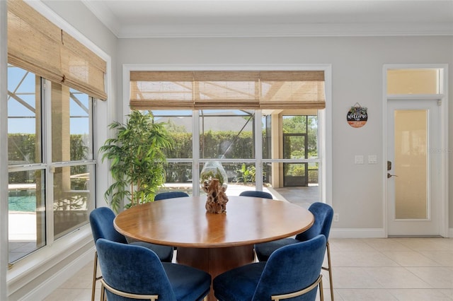 dining space with light tile patterned floors, ornamental molding, and baseboards
