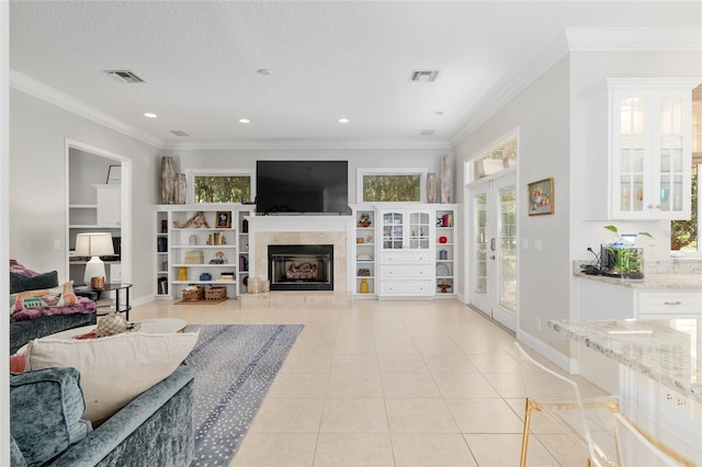 living area featuring crown molding, plenty of natural light, light tile patterned flooring, a fireplace with raised hearth, and recessed lighting