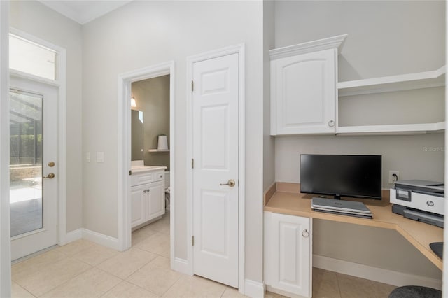 office with built in study area, light tile patterned floors, and baseboards