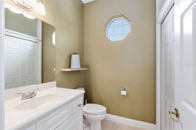 bathroom with toilet, vanity, tile patterned floors, and a closet