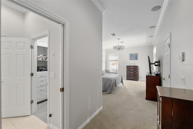 hallway with ornamental molding, light carpet, and baseboards