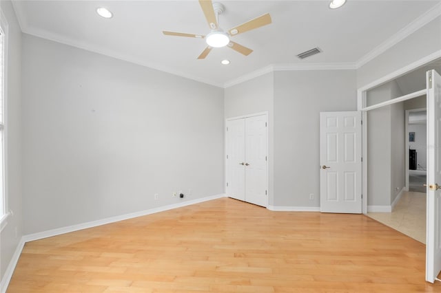 unfurnished bedroom with crown molding, light wood finished floors, recessed lighting, baseboards, and a closet
