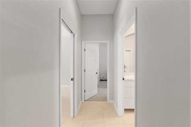 corridor with light tile patterned floors and baseboards
