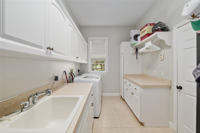 laundry area with washing machine and dryer, cabinet space, light tile patterned floors, and baseboards