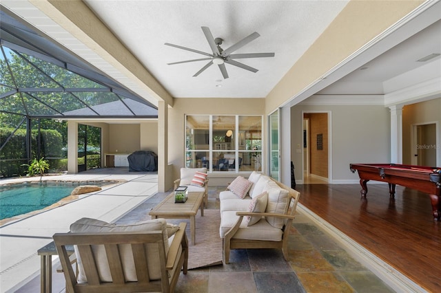 outdoor pool featuring ceiling fan, a patio, an outdoor hangout area, and glass enclosure