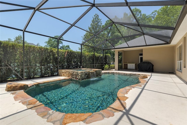 view of pool featuring a patio area, a pool with connected hot tub, and glass enclosure