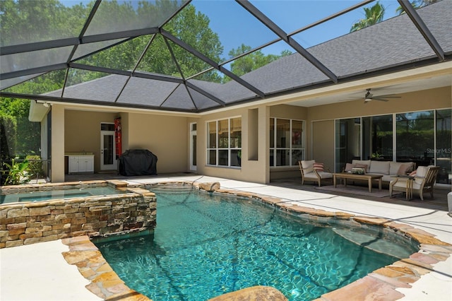 view of pool with a patio, outdoor lounge area, a pool with connected hot tub, a lanai, and a ceiling fan