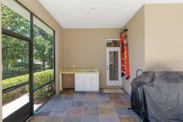 sunroom / solarium featuring plenty of natural light and a sink