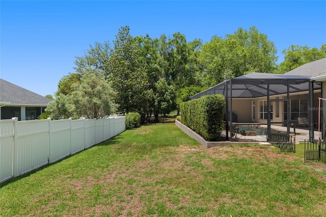 view of yard featuring glass enclosure and a patio area
