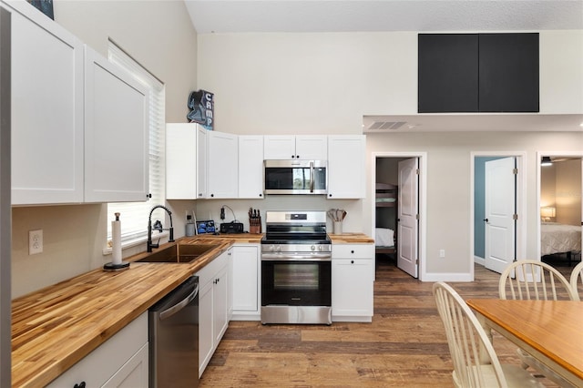 754 SE 167th Court Rd, Silver Springs, FL 34488 - kitchen featuring stainless steel appliances, butcher block countertops, a sink, light wood finished floors, and white cabinetry
