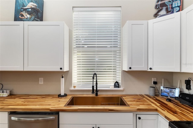 754 SE 167th Court Rd, Silver Springs, FL 34488 - kitchen with butcher block countertops, a sink, stainless steel dishwasher, and white cabinetry