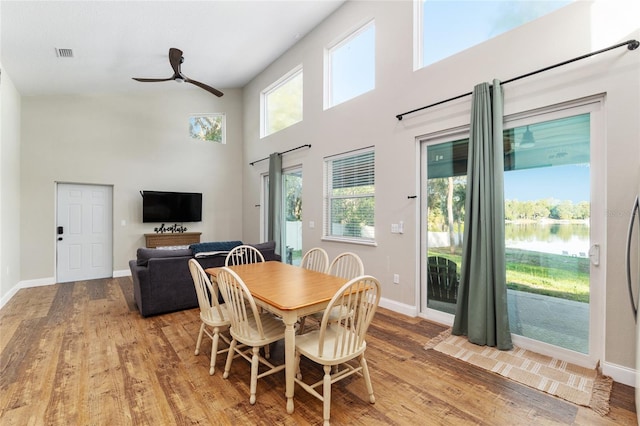 754 SE 167th Court Rd, Silver Springs, FL 34488 - dining area featuring light wood-type flooring, a high ceiling, a ceiling fan, baseboards, and healthy amount of natural light