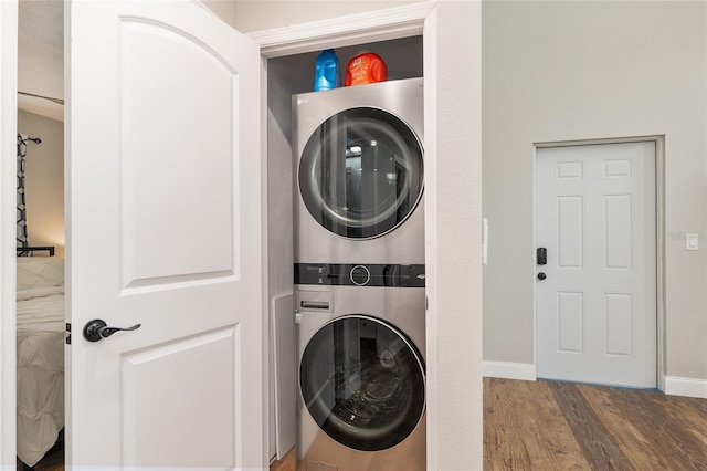754 SE 167th Court Rd, Silver Springs, FL 34488 - laundry area featuring stacked washing machine and dryer, wood finished floors, and baseboards