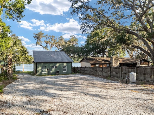 754 SE 167th Court Rd, Silver Springs, FL 34488 - back of house featuring fence, gravel driveway, and a water view