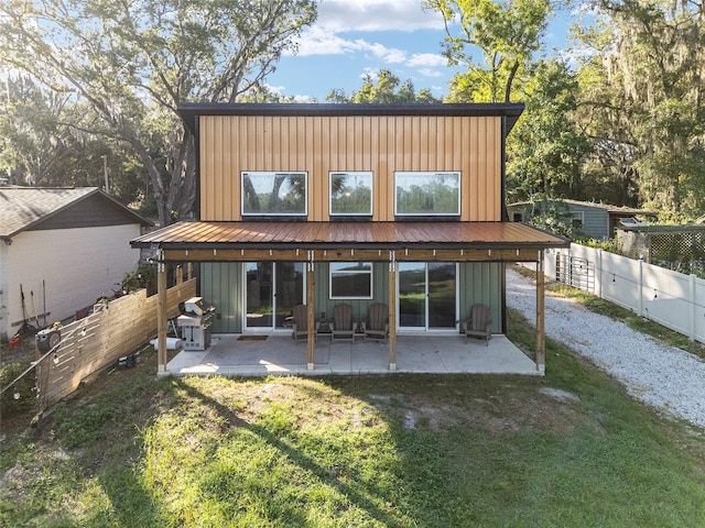 754 SE 167th Court Rd, Silver Springs, FL 34488 - rear view of property with board and batten siding and a patio area