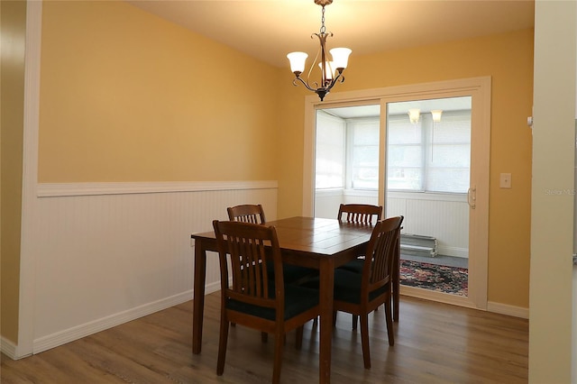 6472 SW 106th Pl, Ocala, FL 34476 - dining area with wood finished floors, a wainscoted wall, and a chandelier