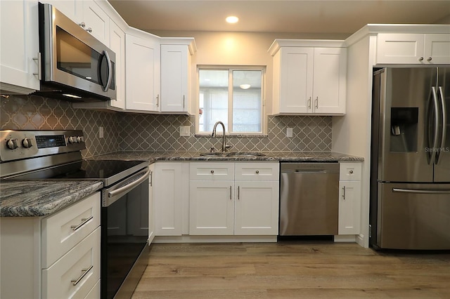 6472 SW 106th Pl, Ocala, FL 34476 - kitchen with appliances with stainless steel finishes, a sink, recessed lighting, white cabinets, and light wood-type flooring