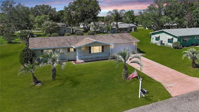 6472 SW 106th Pl, Ocala, FL 34476 - single story home with concrete driveway, covered porch, a lawn, central air condition unit, and an attached garage