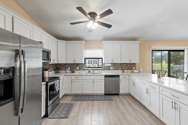 729 Sinclair Ter, Inverness, FL 34450 - kitchen featuring appliances with stainless steel finishes, a sink, healthy amount of natural light, light countertops, and a textured ceiling