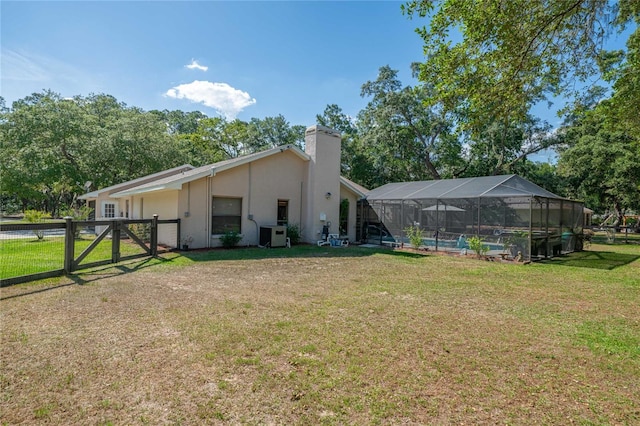 307 N Kinglet Ave, Hernando, FL 34442 - back of house featuring a gate, a chimney, stucco siding, a pool, and a lanai