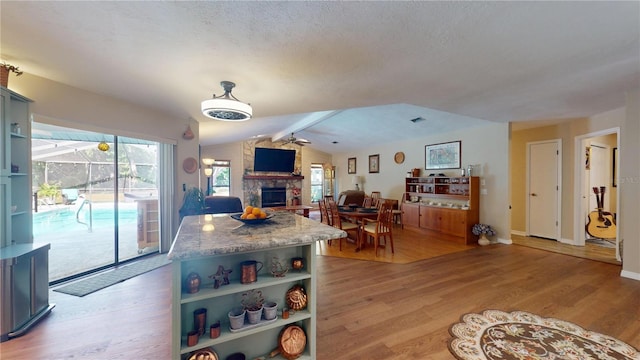 307 N Kinglet Ave, Hernando, FL 34442 - kitchen featuring a stone fireplace, a ceiling fan, light wood-style flooring, open shelves, and baseboards