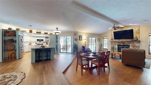 307 N Kinglet Ave, Hernando, FL 34442 - dining room with light wood finished floors, a textured ceiling, ceiling fan, and a stone fireplace