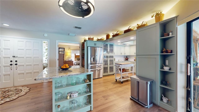307 N Kinglet Ave, Hernando, FL 34442 - kitchen featuring open shelves, stainless steel refrigerator with ice dispenser, light wood-style flooring, and light stone counters