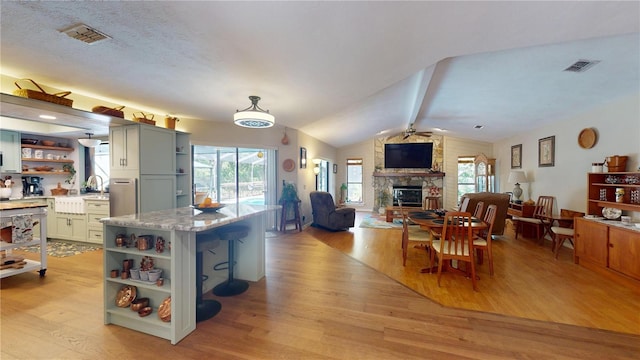 307 N Kinglet Ave, Hernando, FL 34442 - kitchen with open shelves, ceiling fan, light wood finished floors, and a stone fireplace