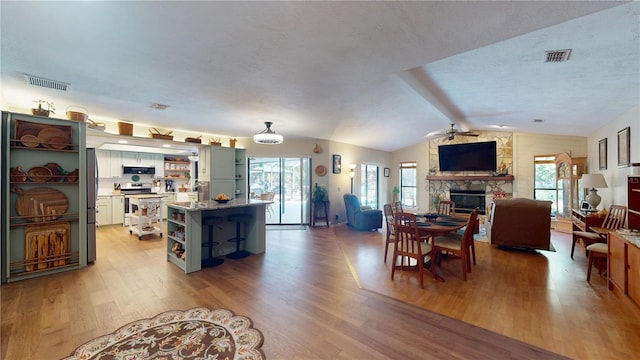 307 N Kinglet Ave, Hernando, FL 34442 - dining room with ceiling fan, a fireplace, light wood-type flooring, and vaulted ceiling