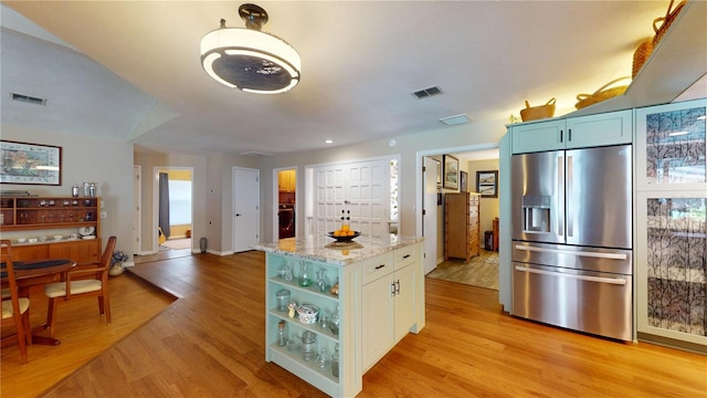 307 N Kinglet Ave, Hernando, FL 34442 - kitchen featuring stainless steel fridge, light wood finished floors, light stone countertops, and a center island