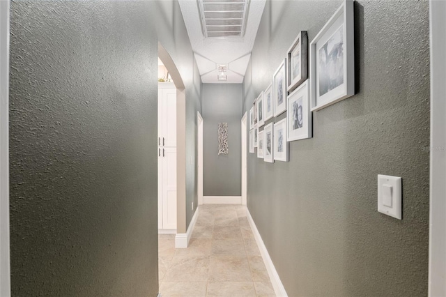 3612 SE 47th Ter, Ocala, FL 34480 - hallway featuring a textured wall, light tile patterned flooring, arched walkways, and baseboards