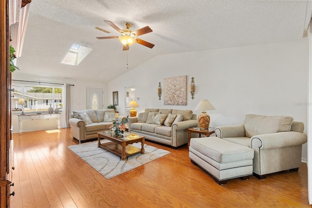 17576 SE 96th Ct, Summerfield, FL 34491 - living room with a skylight, ceiling fan, a textured ceiling, vaulted ceiling, and light wood-type flooring
