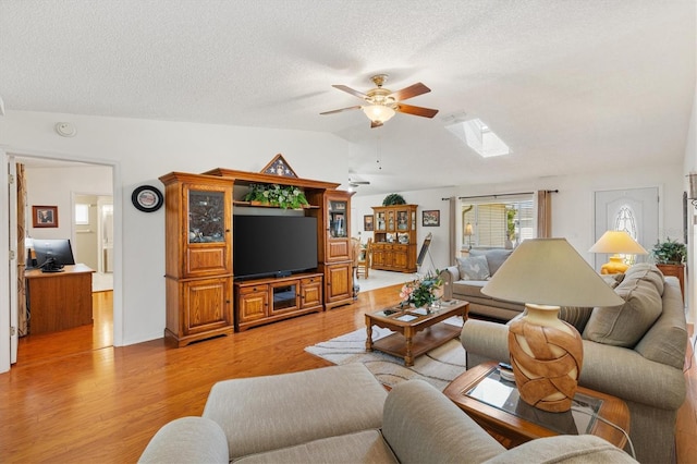 17576 SE 96th Ct, Summerfield, FL 34491 - living room with lofted ceiling, ceiling fan, light wood-type flooring, a textured ceiling, and a skylight