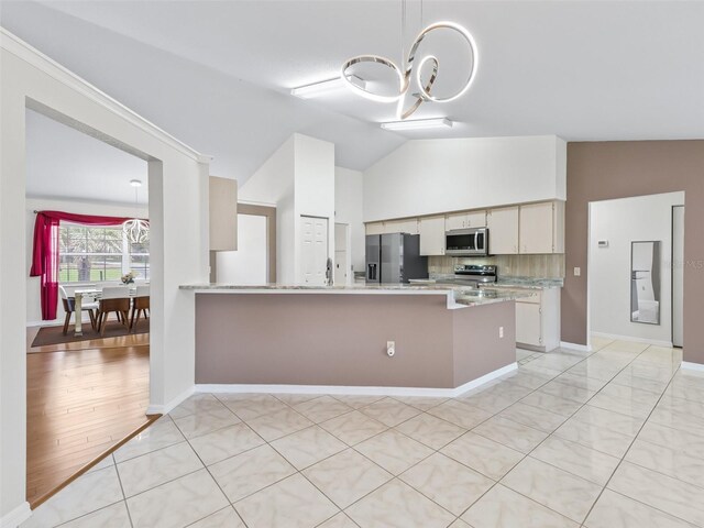 17233 SE 115th Terrace Rd, Summerfield, FL 34491 - kitchen with appliances with stainless steel finishes, a chandelier, lofted ceiling, a peninsula, and baseboards