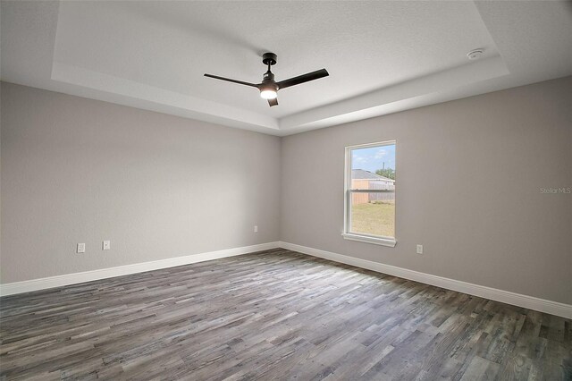 20 Emerald Trl, Ocala, FL 34472 - unfurnished room featuring a tray ceiling, dark wood-style flooring, ceiling fan, and baseboards