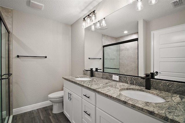 20 Emerald Trl, Ocala, FL 34472 - bathroom featuring a shower stall, toilet, wood finished floors, a textured ceiling, and double vanity