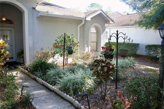 8735 SW 192nd Court Rd, Dunnellon, FL 34432 - doorway to property with stucco siding and roof with shingles