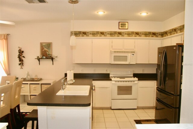 8735 SW 192nd Court Rd, Dunnellon, FL 34432 - kitchen with white appliances, a sink, dark countertops, white cabinets, and light tile patterned flooring