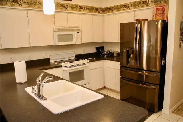 8735 SW 192nd Court Rd, Dunnellon, FL 34432 - kitchen featuring white appliances, a sink, dark countertops, and white cabinets