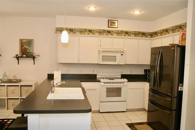 8735 SW 192nd Court Rd, Dunnellon, FL 34432 - kitchen featuring white appliances, a sink, dark countertops, a peninsula, and white cabinetry