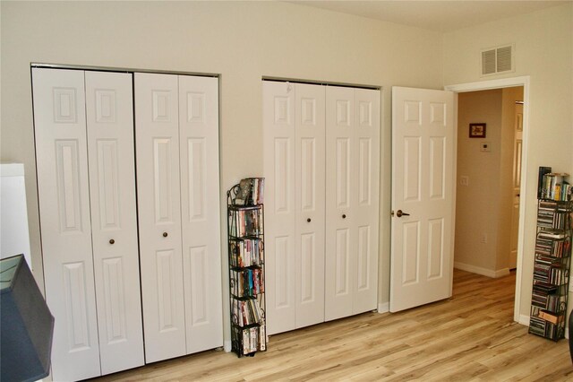 8735 SW 192nd Court Rd, Dunnellon, FL 34432 - bedroom with multiple closets, light wood-style floors, and baseboards
