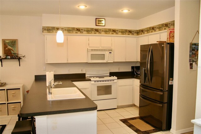8735 SW 192nd Court Rd, Dunnellon, FL 34432 - kitchen featuring white appliances, a sink, dark countertops, white cabinetry, and light tile patterned floors