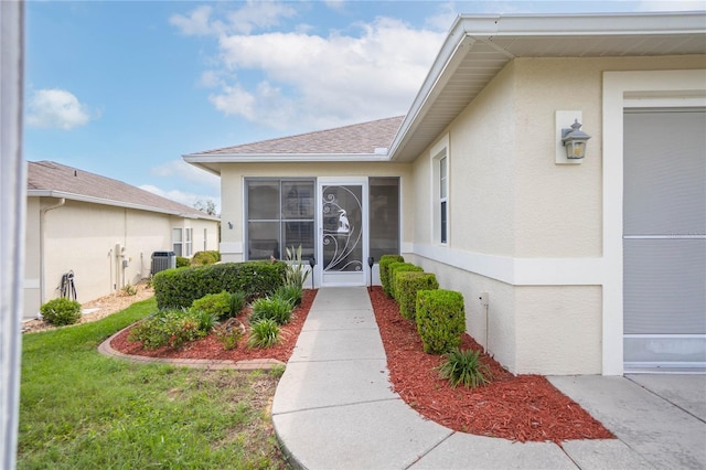 4692 N Lake Vista Trl, Hernando, FL 34442 - entrance to property featuring stucco siding, central AC unit, and roof with shingles