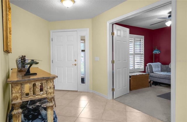 4692 N Lake Vista Trl, Hernando, FL 34442 - foyer with a textured ceiling, light tile patterned floors, baseboards, ceiling fan, and light colored carpet