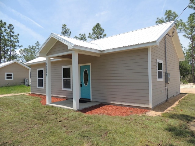 13391 NE 51st St, Williston, FL 32696 - view of front of home with a front yard, metal roof, and a patio area