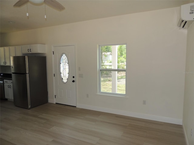 13391 NE 51st St, Williston, FL 32696 - foyer featuring light wood-type flooring, baseboards, a ceiling fan, and an AC wall unit