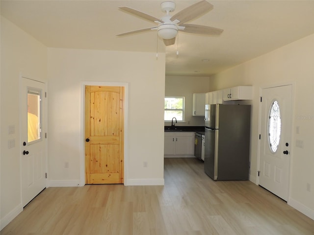 13391 NE 51st St, Williston, FL 32696 - kitchen with appliances with stainless steel finishes, light wood finished floors, white cabinets, dark countertops, and a ceiling fan