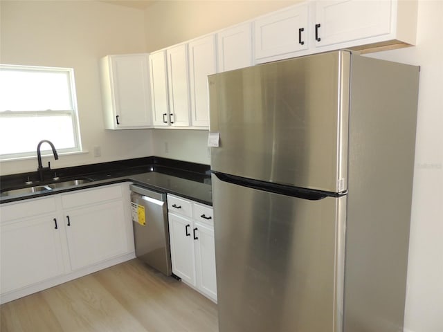 13391 NE 51st St, Williston, FL 32696 - kitchen with appliances with stainless steel finishes, a sink, dark countertops, and white cabinetry