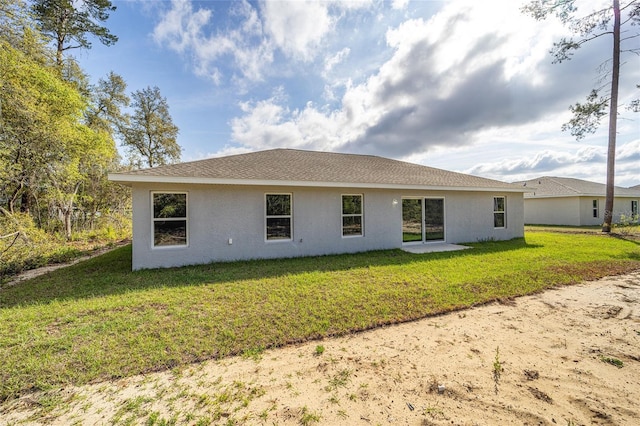 3684 W Fountain Ln, Citrus Springs, FL 34433 - back of property featuring stucco siding and a lawn