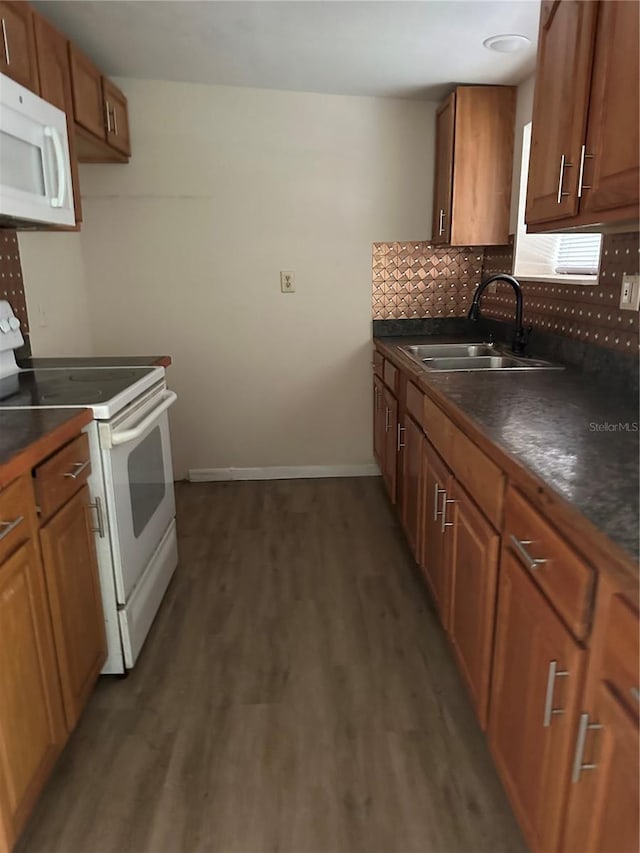 312 NW 28th St, Ocala, FL 34475 - kitchen with white appliances, a sink, dark countertops, tasteful backsplash, and dark wood-type flooring